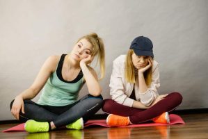 two-attractive-women-wearing-sports-clothes-sitting-exercise-mat-being-bored-tired-hard-workout-two-sporty-women-being-140295591